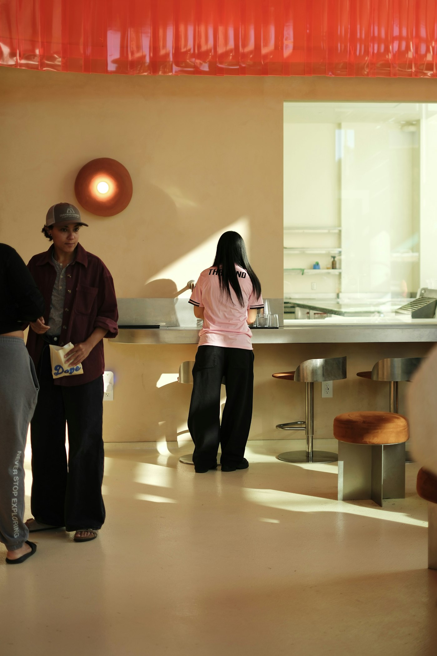 A customer waiting near the counter inside a small modern café